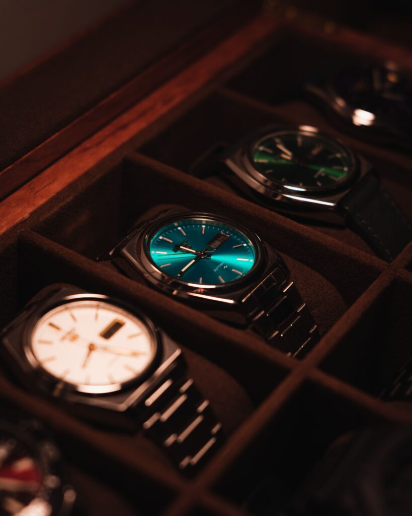 Showcase of Authentic luxury watches in a display case with warm lighting.
