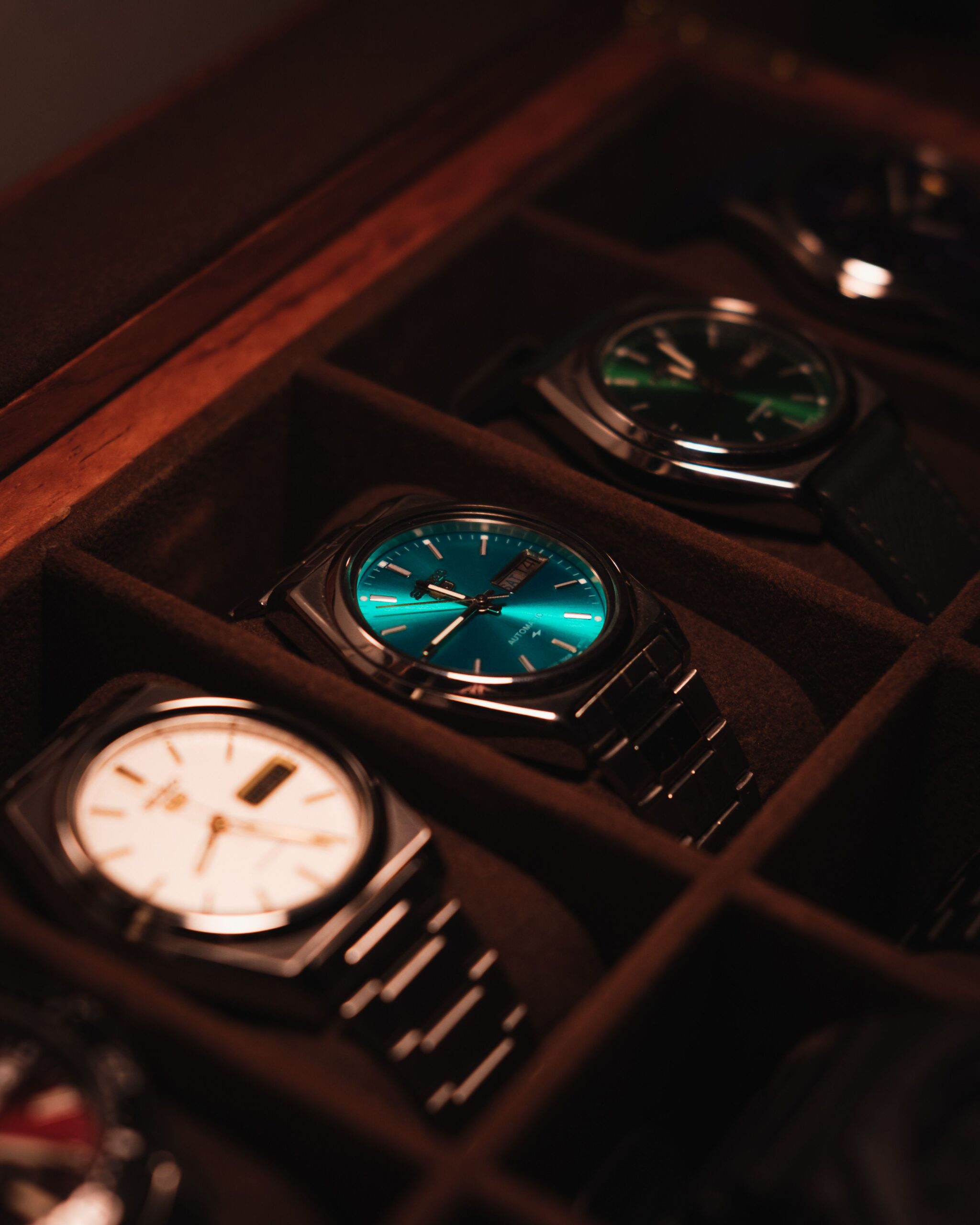 Showcase of Authentic luxury watches in a display case with warm lighting.
